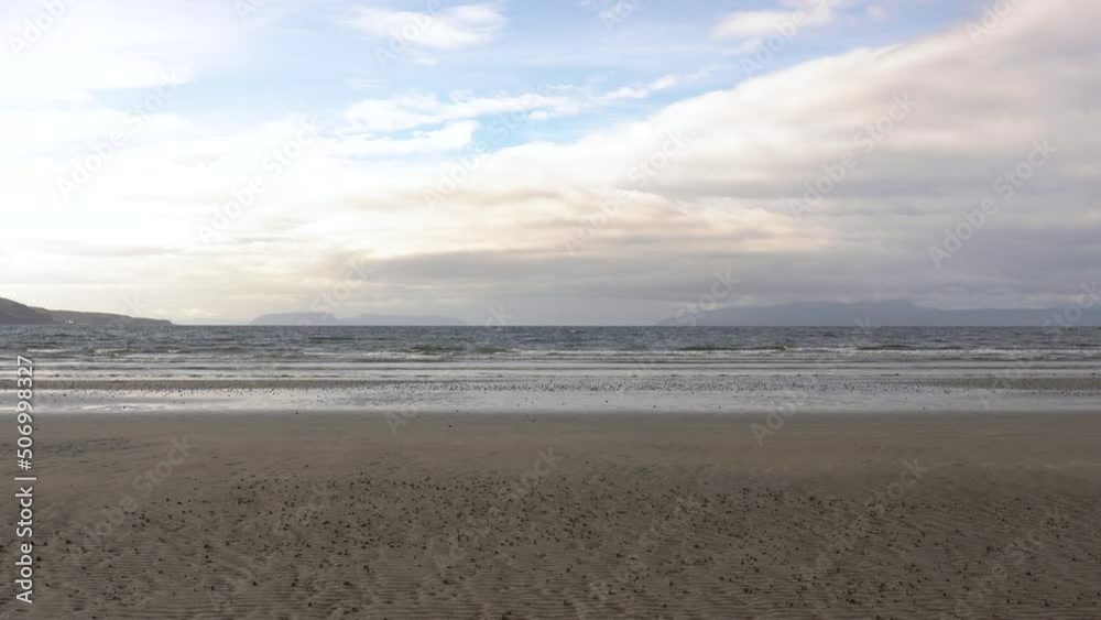 A tranquil Scottish Sandy Beach on the Isle of Skye with the Waves rolling in A tranquil Scottish Sandy Beach on the Isle of Skye with the Waves rolling in