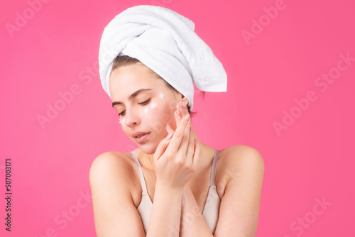 Beauty face portrait. Spa therapy, beautiful woman in towel takes care of skin, isolated on pink.