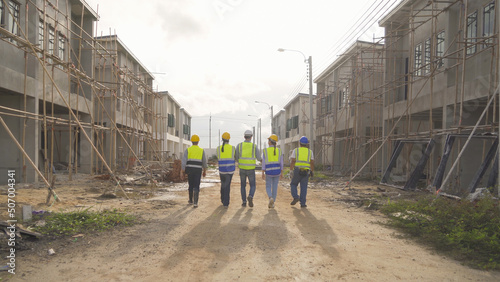 A group of workers, a designer team talk, communicate, discuss, and working on industrial construction site at home architecture building project. People lifestyle.