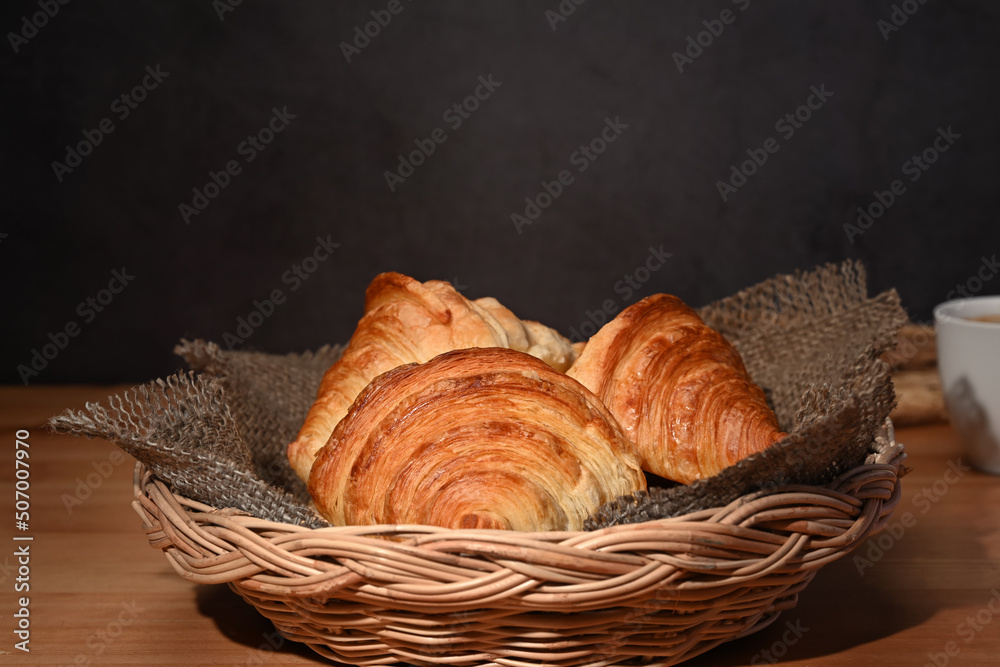 Fresh baked croissant in wicker basket. Levitation, bread bakery products cafe concept