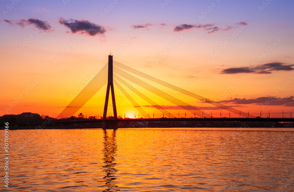 picturecque view from water surface to large river and cable - stayed bridge