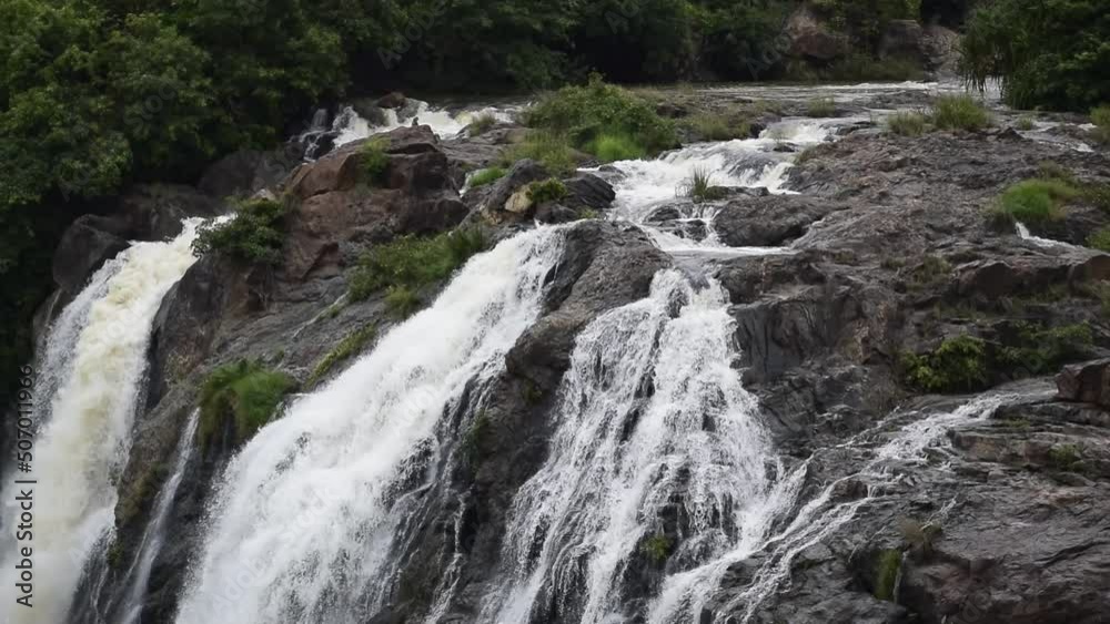 High speed waterfall with water colliding with trees and rocks. A Beautiful spectacle to watch High speed waterfall with water colliding with trees and rocks. A Beautiful spectacle to watch
