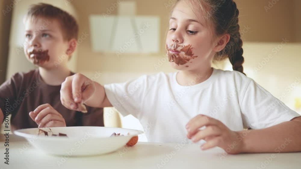 baby boy and girl eat chocolate. dirty little baby kids in the kitchen eating chocolate in the morning. happy family lifestyle eating sweets kid dream concept. baby dirty face eating chocolate cocoa baby boy and girl eat chocolate. dirty little baby kids in the kitchen eating chocolate in the morning. happy family lifestyle eating sweets kid dream concept. baby dirty face eating chocolate cocoa