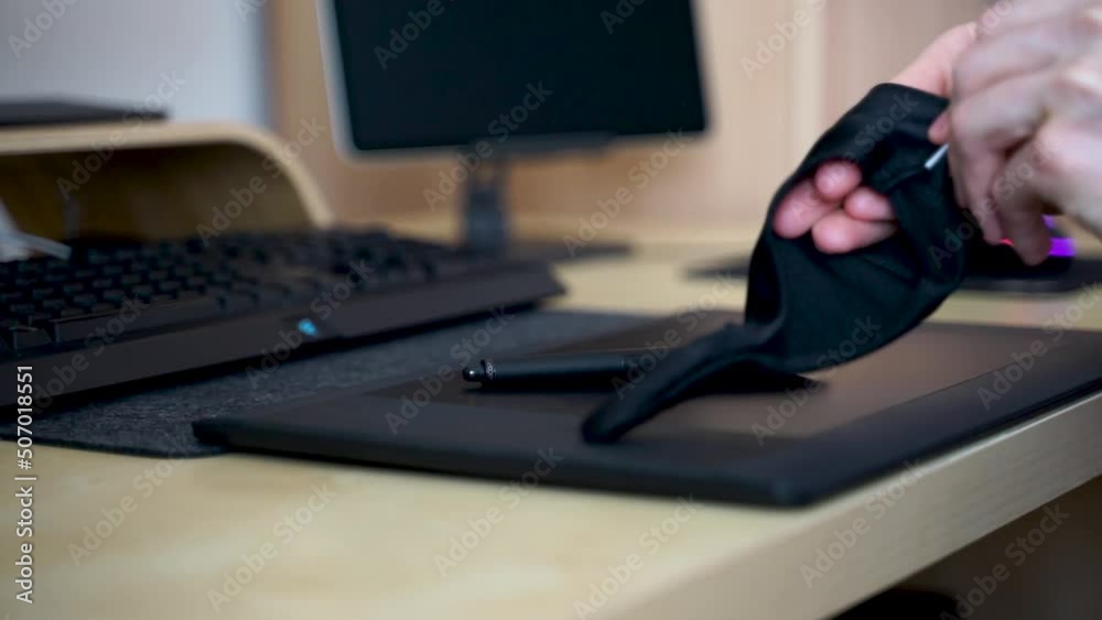 Close-up of hand drawing on a digital tablet with pen. Professional retoucher working on graphic tablet.