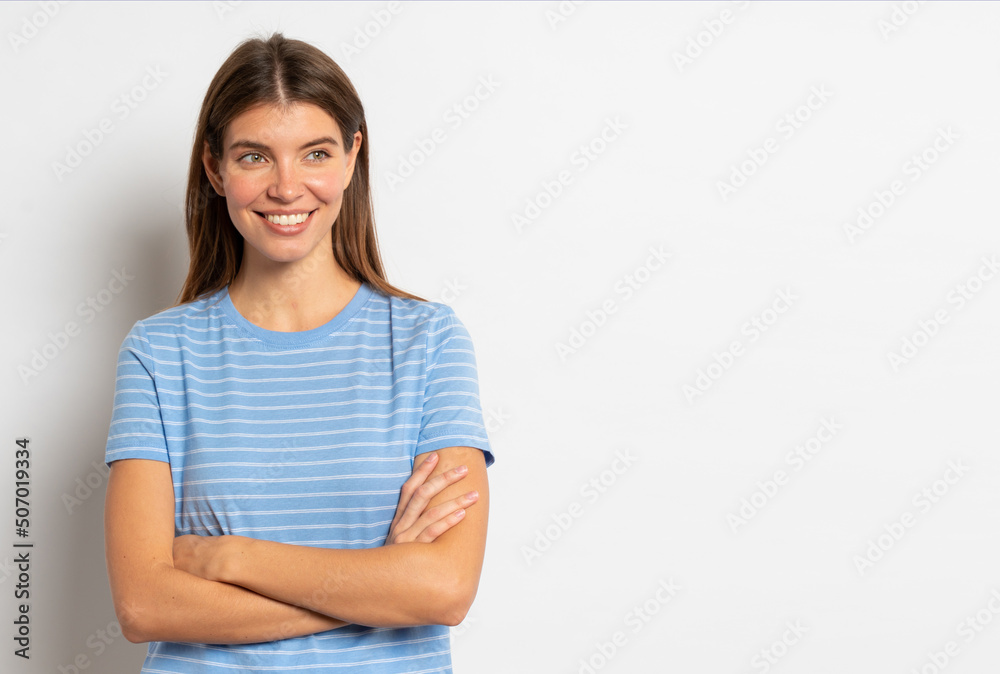 Smiling pensive woman in striped casual clothes standing with folded arms on white background Smiling pensive woman in striped casual clothes standing with folded arms on white background