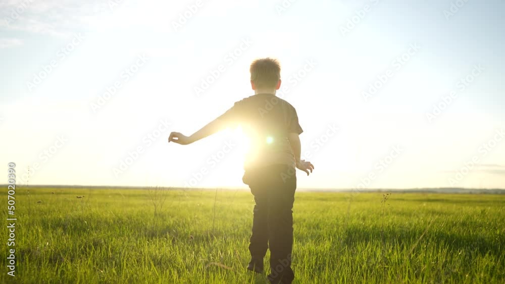 boy running in the park. happy family a kid dream concept. child son boy 8 years old running on the grass in the summer in the park rear view at lifestyle sunset. kid run in nature boy running in the park. happy family a kid dream concept. child son boy 8 years old running on the grass in the summer in the park rear view at lifestyle sunset. kid run in nature