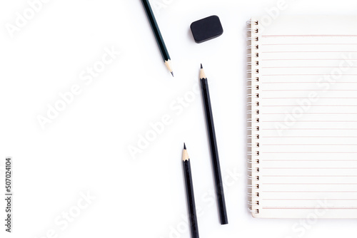 Notebook , Black pencils and black eraser isolated on white background