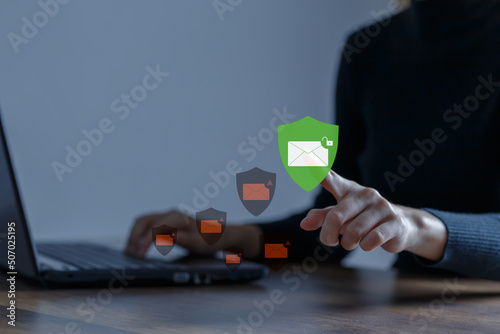 Business woman using computer to access email with anti-spam e-mail. Cyber attack prevention and cybersecurity concept. photo