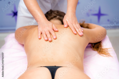 Facial massage. A woman is given a massage in a beauty salon. Close-up.