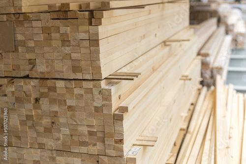 Wooden long rectangular bars in a stack. Dry planed block made of solid wood for construction. Building materials. View from the end.