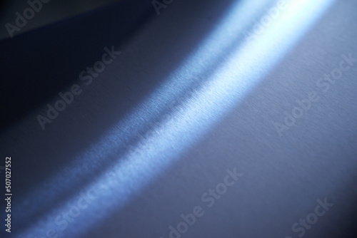 Stainless steel texture. Metal texture. Texture of stainless steel with an accent of light. A beam of light on a blue metallic background.