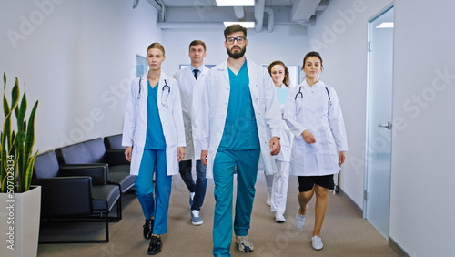 Modern private hospital multiethnic team of doctors and nurses posing in front of the camera and looking straight