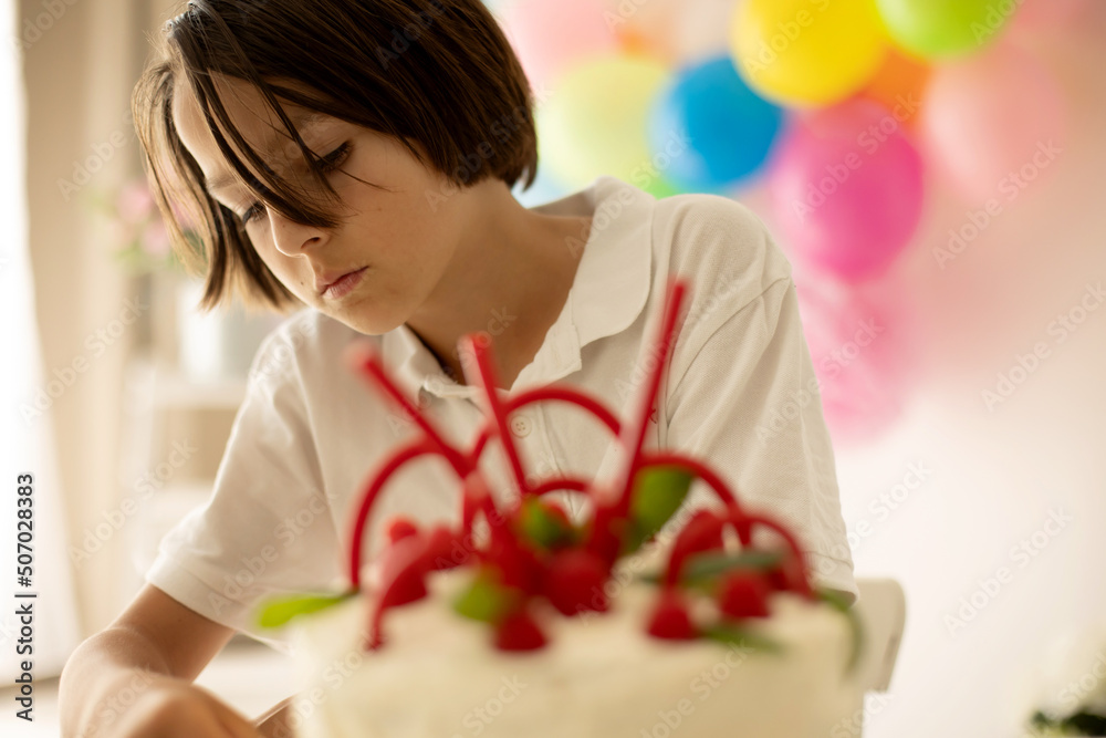 Cute child, preschool boy, celebrating birthday at home with homemade cake with raspberries, mint and candies Cute child, preschool boy, celebrating birthday at home with homemade cake with raspberries, mint and candies