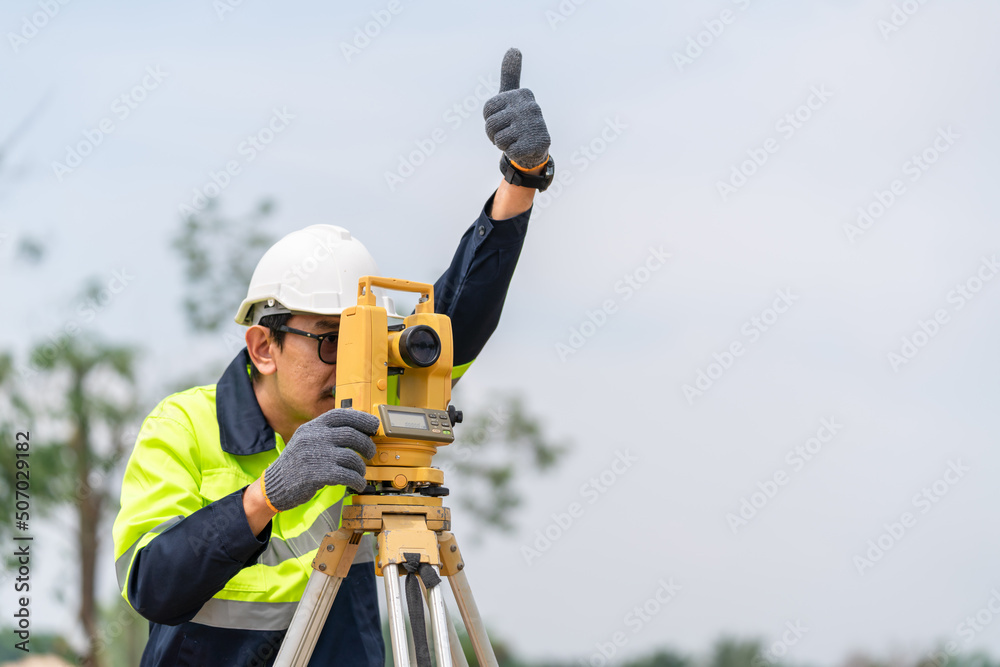 Surveyor Civil Engineer thumbs up with equipment on the construction site. Surveyor Civil Engineer thumbs up with equipment on the construction site.