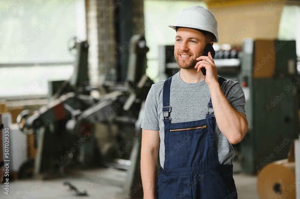 Management team, engineer, or foreman. Standing checking job information about industrial production management within the factory by phone. Teamwork concept Management team, engineer, or foreman. Standing checking job information about industrial production management within the factory by phone. Teamwork concept