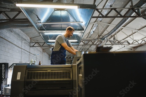 Wallpaper Mural Portrait of production line worker controlling manufacturing process of modern packaging industrial machine in printing factory Torontodigital.ca