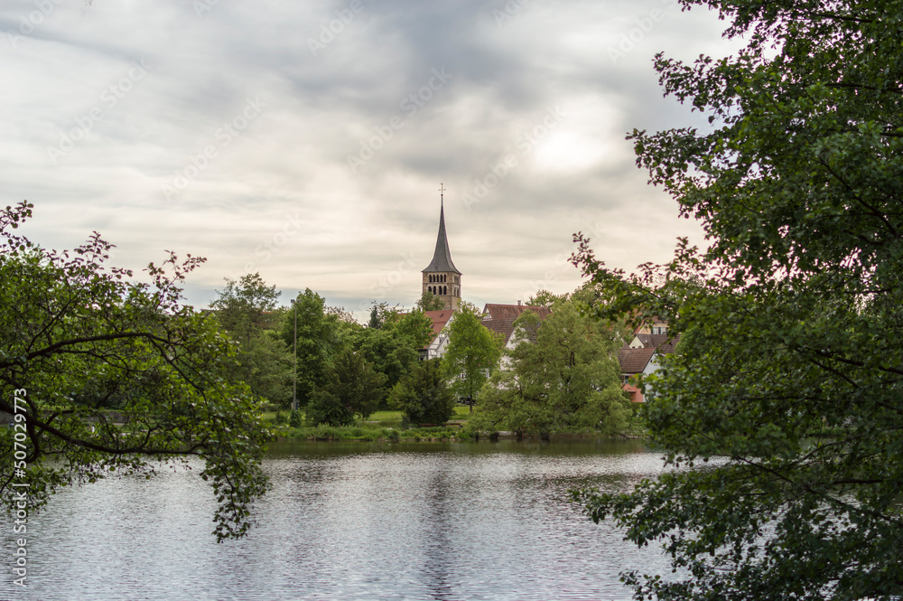 View over Klostersee lake in Sindelfingen, Germany, with old church tower in the middle of the photo.
