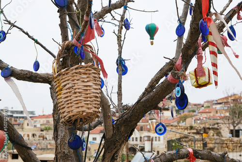 Evil eye beads or nazar boncugu on the old tree in Cappadocia. Activities in Cappadocia. Amulets protects from bad things in Turkish Culture photo