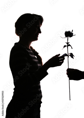 Silhouette of a woman receiving a rose from a man, symbolizing love and romance. Black and white profile isolated on white background, ideal for Valentine’s Day themes.