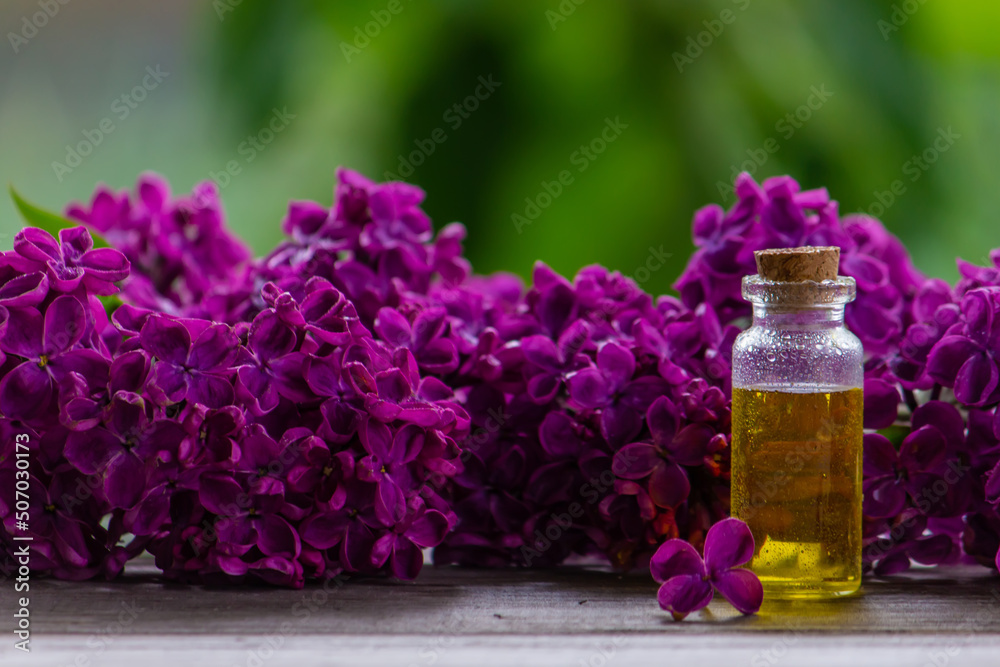 Lilac essential oil in a small bottle. Selective focus. Lilac essential oil in a small bottle. Selective focus.