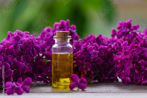 Lilac essential oil in a small bottle. Selective focus.