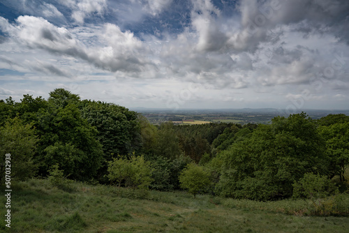 British hillside view over Worcestershire with trees and meadows under a cloudy sky