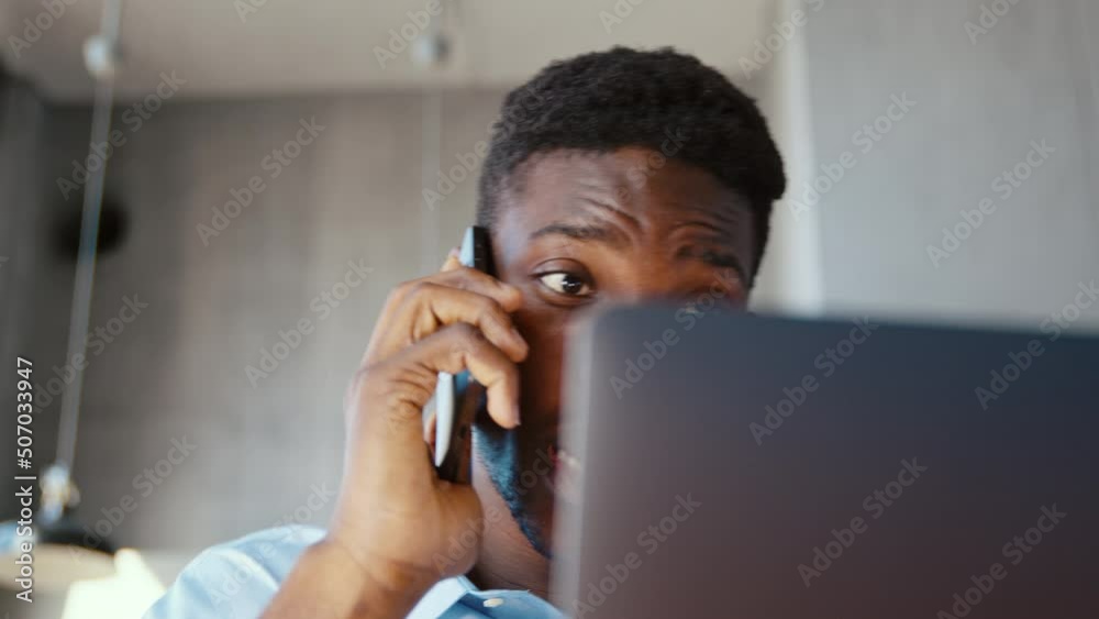 Serious businessman talking on the phone and working in computer