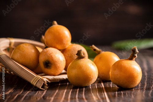 ripe loquat fruit on wooden table photo