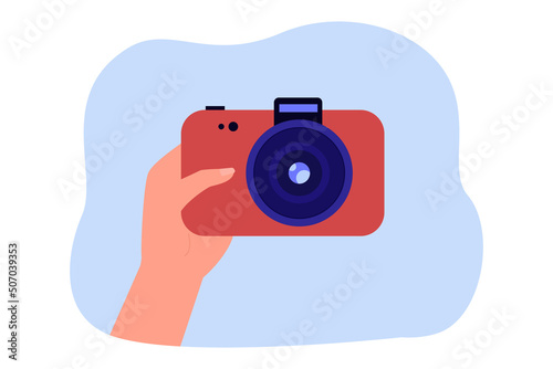 Hand of photographer holding red camera. Person buying camera or taking photo flat vector illustration. Photography, hobby, memories concept for banner, website design or landing web page