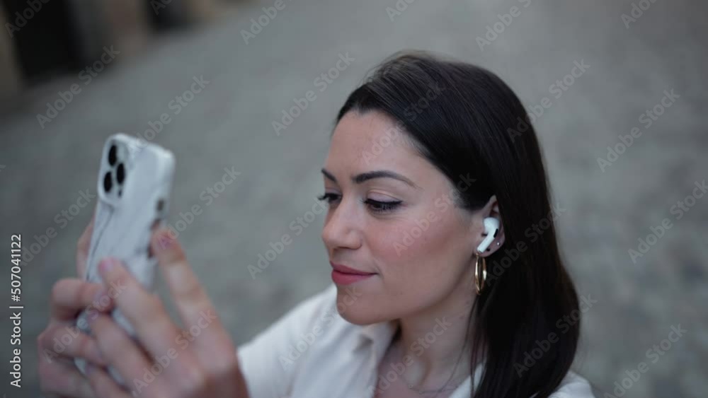 Handsome brunette woman in headphones making photo of the street Handsome brunette woman in headphones making photo of the street