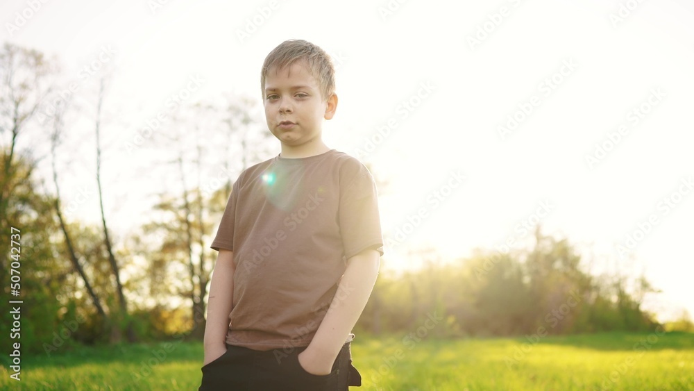 lifestyle little boy outdoor portrait. happy family kid a dream concept. child close-up in the park in nature looking to the side. boy kid portrait in the background grass forest park lifestyle little boy outdoor portrait. happy family kid a dream concept. child close-up in the park in nature looking to the side. boy kid portrait in the background grass forest park