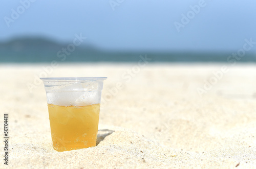 Cold vietnamese beer in cup with ice on white sand beach of Nha Trang Vietnam