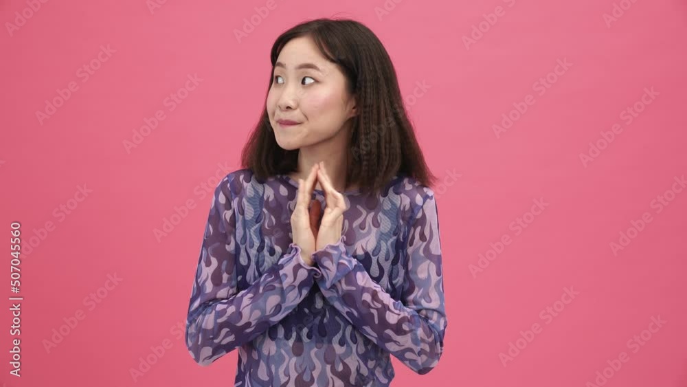 Handsome Asian woman looking around in the pink studio Handsome Asian woman looking around in the pink studio