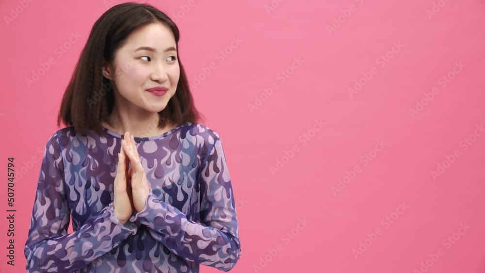 Pretty Asian woman waiting for something in the pink studio Pretty Asian woman waiting for something in the pink studio