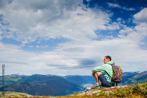 Fototapeta Naklejka Na Ścianę i Meble -  Freedom traveler man sitting upper the fjord and enjoying a beautiful nature