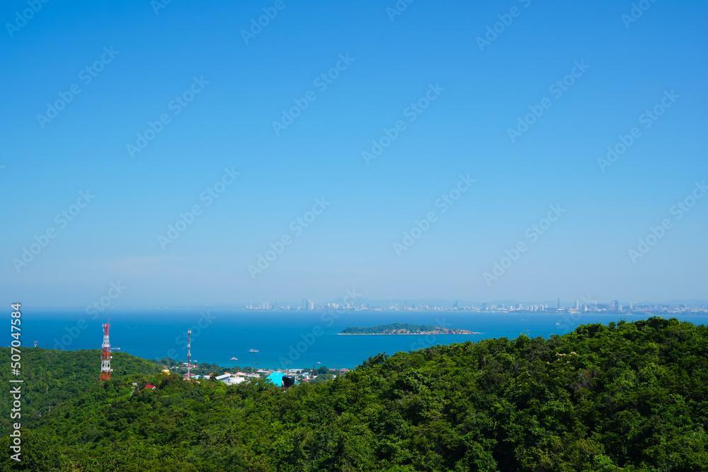 Beautiful viewpoints of Koh Larn island, bright blue skyline, deep turquoise shade of sea water, green tree mountain and cityscape around bay. Landmark and travel destination of Pattaya thailand.