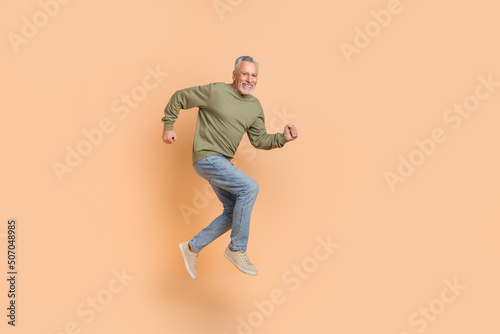 Full body photo of impressed old grey hairdo man run wear pullover jeans footwear isolated on beige background