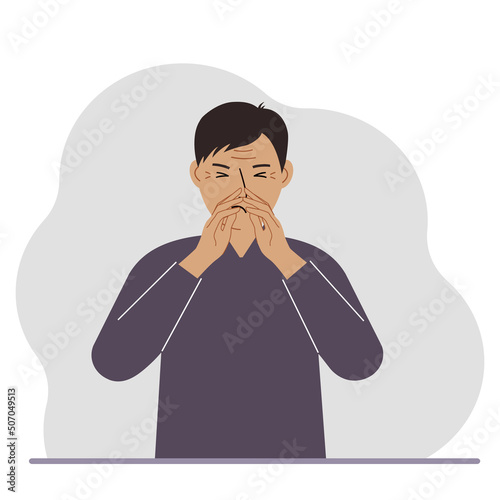 The man covers his nose with his hands. The concept of a sick person, sneezes, seasonal allergies, bad smell.