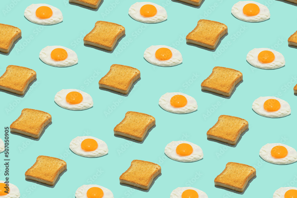 Seamless creative food pattern. Fried eggs and toasts on a blue background. Funny colorful breakfast concept. Seamless creative food pattern. Fried eggs and toasts on a blue background. Funny colorful breakfast concept.