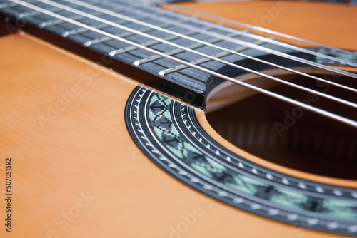 Classical guitar close up. Acoustic guitar background, strings, frets, pegs.