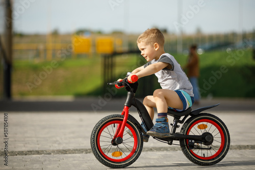 little boy riding a bike in a city park © Ruslan Ivantsov