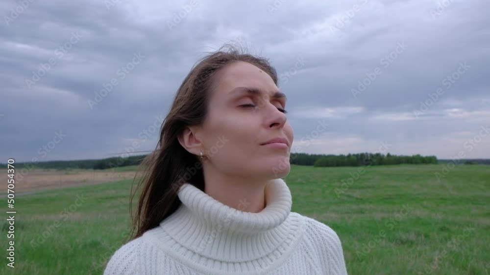 Peaceful Brunette Woman in white sweater close up her eyes enjoying calm foggy day in the nature, breathing fresh air, Freedom Or Happiness Concept. Slowmotion. Peaceful Brunette Woman in white sweater close up her eyes enjoying calm foggy day in the nature, breathing fresh air, Freedom Or Happiness Concept. Slowmotion.
