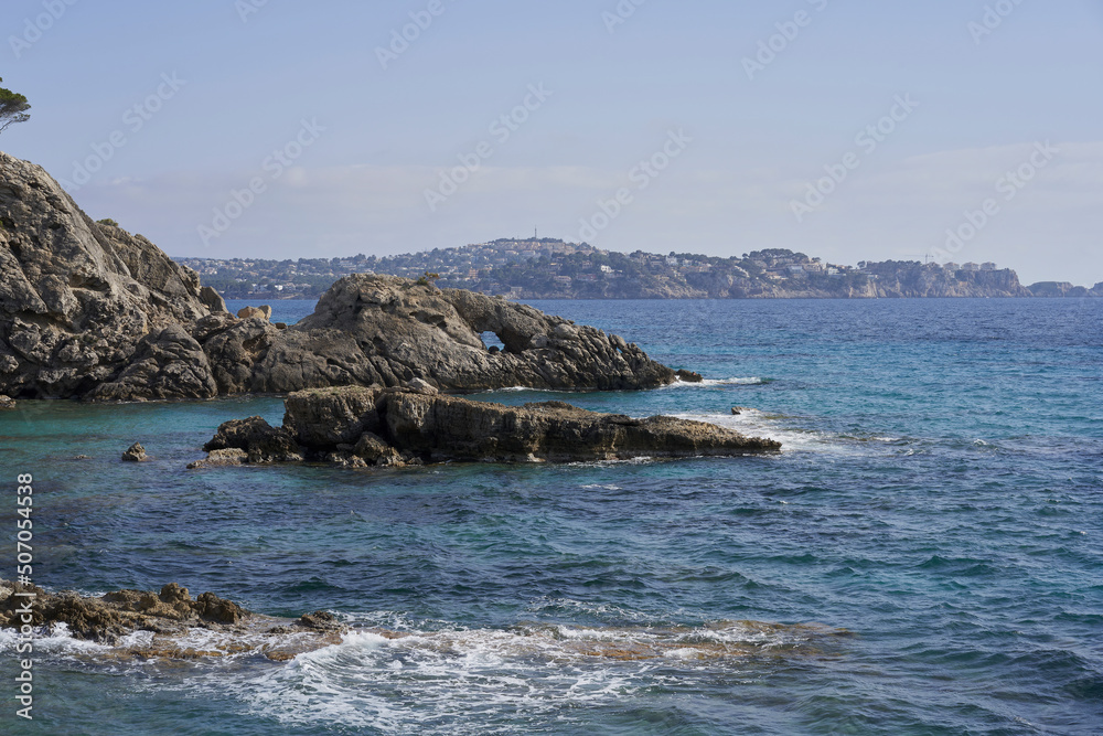 Calo Puig des Gats, cove with crystal clear waters and rocky bottom, in the background the town of Santa Ponsa. Peguera, municipality of Calviá, Majorca
