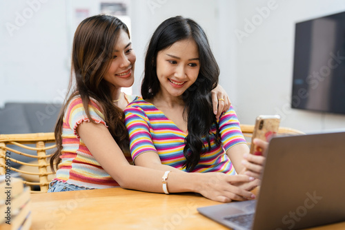 lgbtq, lgbt concept, homosexuality, portrait of two asian women posing happy together and loving each other while playing computer laptop