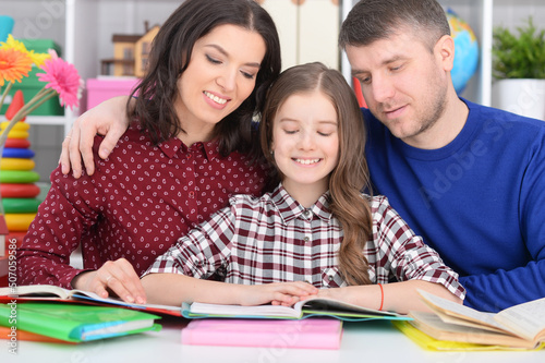 parents and daughter doing homework