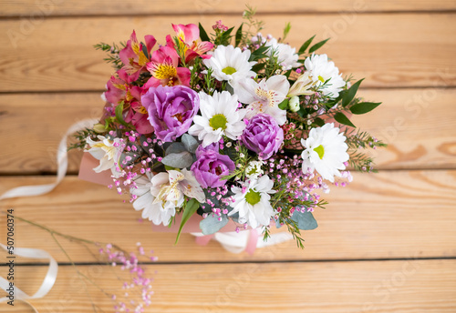 bouquet of wildflowers in a box on a wooden background © viktoriya