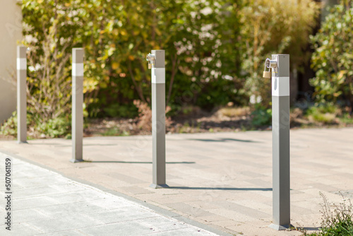 Bollards at concrete pavement. Traffic Gate with padlock. Bollards on footpath Entrance to Private Territory. photo