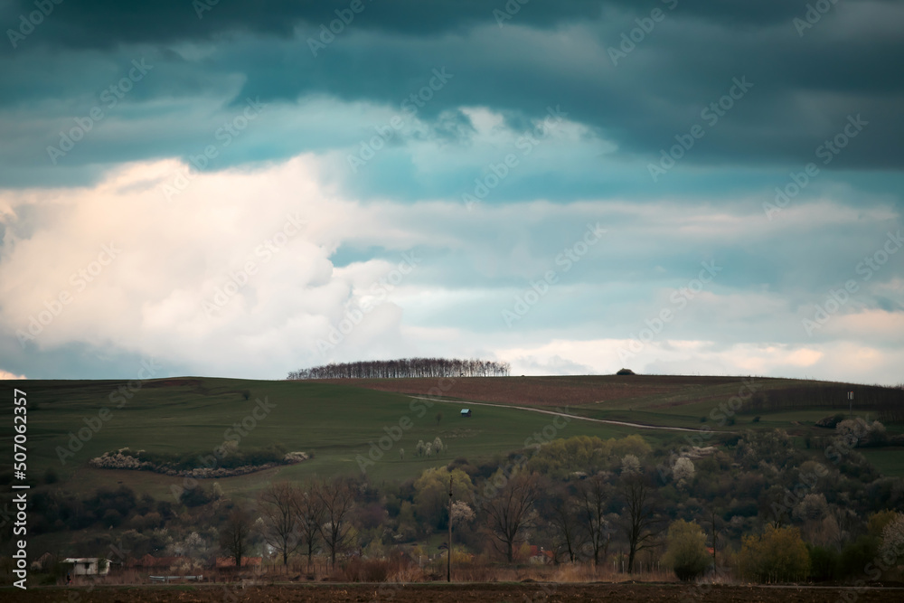 Spring landscape with large clouds. Before the rain. Rural landscape.