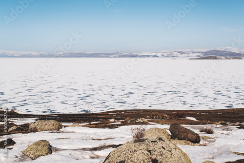 Landscape view of Frozen Cildir lake in Kars and snowy mountains with a blue sky in winter photo