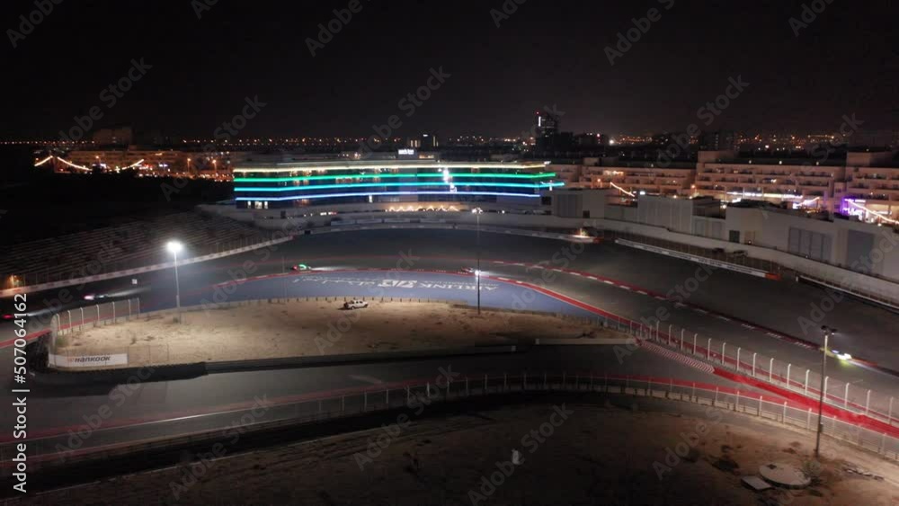 Aerial view of car racing in corner, Dubai Autodrome race track during night endurance competition